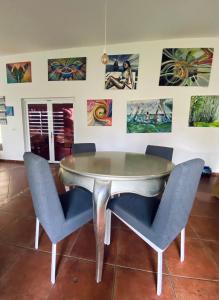 mesa de comedor con sillas y pinturas en la pared en Villa cerca del Mar, en Guanche