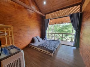a bedroom with a bed and a large window at An Nhien Farm - Venuestay in Buon Ma Thuot