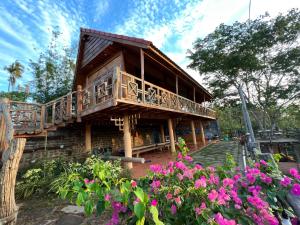 a building with a balcony and some flowers at An Nhien Farm - Venuestay in Buon Ma Thuot