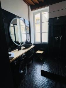 a black bathroom with a sink and a mirror at Le Grand Cerf By La Chambre à Côté in Metz