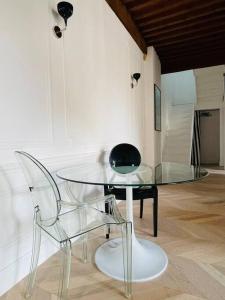 una mesa de cristal y una silla en una habitación en Le Grand Cerf By La Chambre à Côté, en Metz