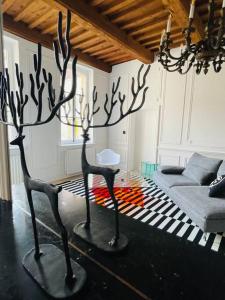 a living room with two metal sculptures on the floor at Le Grand Cerf By La Chambre à Côté in Metz