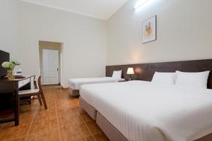 Postel nebo postele na pokoji v ubytování BIDV Central Da Lat Hotel