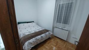 a small bedroom with a bed and a window at Apartman Zapadni Kej M&M in Pirot