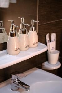 a bathroom with three soap dispensers on a sink at BIDV Central Da Lat Hotel in Da Lat