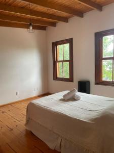 a bedroom with a large bed with two windows at Tranquilidad en Bragado in Bragado