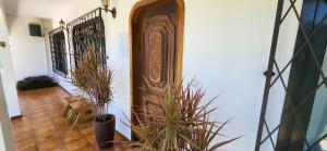 um corredor com vasos de plantas e uma porta de madeira em Casa Hoffmann em Pomerode