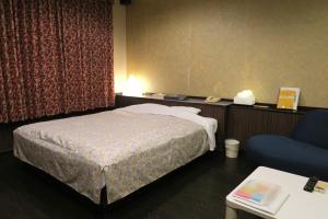 a hotel room with a bed and a chair at Hotel Carnival (Love Hotel) in Miyaki
