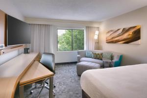 a hotel room with a bed and a desk and a chair at Courtyard by Marriott Oklahoma City Northwest in Oklahoma City