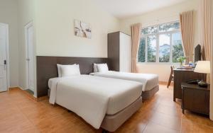 Postel nebo postele na pokoji v ubytování BIDV Central Da Lat Hotel