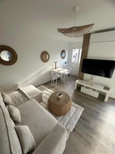 uma sala de estar com um sofá e uma televisão de ecrã plano em MarbleMood Spa em Obernai
