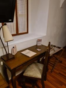 un bureau en bois avec une lampe et une chaise dans l'établissement Hotel Casa Divina Oaxaca, à Oaxaca