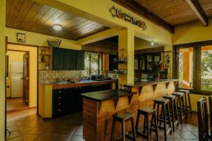 una cocina con encimera y algunos taburetes en ella en Villa Ka: Relax with fresh air and mountain view., en Jarabacoa