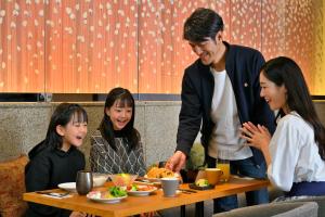 a group of people sitting around a table eating food at KAYA Kyoto Nijo Castle, BW Signature Collection by Best Western in Kyoto
