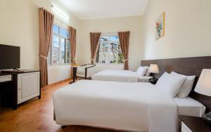 Postel nebo postele na pokoji v ubytování BIDV Central Da Lat Hotel