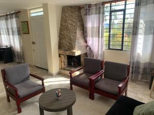 sala de estar con 2 sillas y chimenea en Casa campestre Boyacá, cerca a lugares turísticos en Duitama