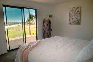 a bedroom with a bed and a sliding glass door at kentonviewsestate in Gumeracha