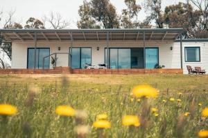 une maison avec un champ de fleurs devant elle dans l'établissement kentonviewsestate, à Gumeracha