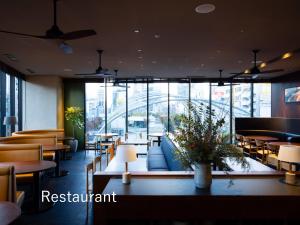a restaurant with tables and chairs and windows at sequence MIYASHITA PARK - Shibuya in Tokyo