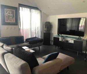 a living room with a couch and a flat screen tv at Modern cool 3 bed hideaway in Marrickville/Enmore in Sydney