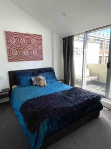 a teddy bear sitting on a bed in a bedroom at Modern cool 3 bed hideaway in Marrickville/Enmore in Sydney