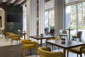 a restaurant with tables and chairs and windows at San Ramon Marriott in San Ramon