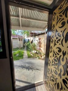 une porte menant à une terrasse par une porte en verre. dans l'établissement Maharani Homestay, à Gorontalo
