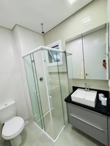 a bathroom with a shower and a toilet and a sink at Estadia perfeita em Florianópolis: Apartamento com 2 Quartos, 1 Suíte e Churrasqueira no Ribeirão da Ilha - Uma Oportunidade Imperdível in Florianópolis