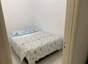 a small bed in a small room with a white wall at Apto Leme RJ- Lindo 2 quartos. A uma quadra da praia. in Rio de Janeiro