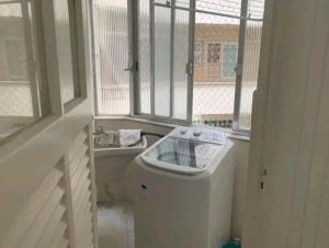 a bathroom with a washing machine and a window at Apto Leme RJ- Lindo 2 quartos. A uma quadra da praia. in Rio de Janeiro