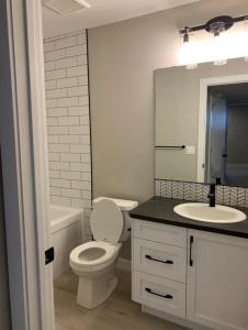 biała łazienka z toaletą i umywalką w obiekcie New Townhouse in Red Deer w mieście Red Deer