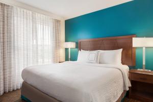 Residence Inn By Marriott Las Vegas Stadium Area في لاس فيغاس: غرفة نوم بسرير كبير وجدار ازرق
