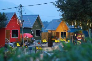 a row of houses with yellow chairs in a yard at Konfudha Resort in Kalpetta