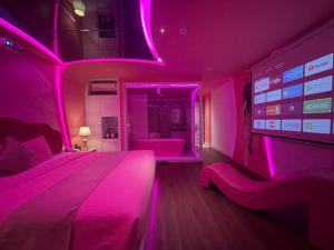 um quarto cor-de-rosa com uma cama e um ecrã de projecção em Chiic House 2 - Khách sạn tình yêu em Da Nang