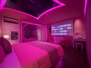 Chiic House 2 - Khách sạn tình yêu في دا نانغ: غرفة نوم وردية مع سرير وتلفزيون