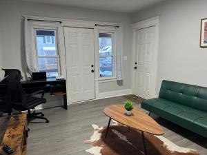 a living room with a green couch and a desk at Perfect stay for couples in Springfield