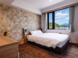 1 dormitorio con cama y ventana grande en ホテル紀伊田辺, en Tanabe