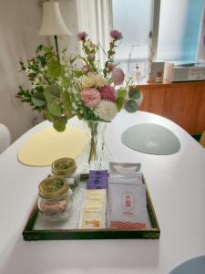 un jarrón con flores y otros artículos sobre una mesa en JB Stay#Hongdae & Sinchon 10min#Double Room, en Seúl