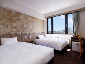um quarto de hotel com duas camas e uma janela em ホテル紀伊田辺 em Tanabe