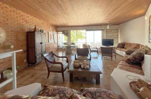 un soggiorno con divano e tavolo di Extraordinária casa Pé na Areia - Piçarras a Piçarras