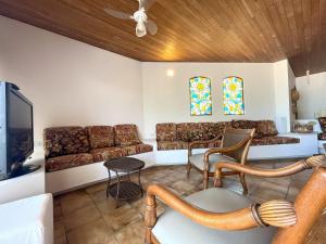 un soggiorno con divano e TV di Extraordinária casa Pé na Areia - Piçarras a Piçarras