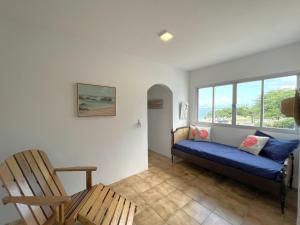 un soggiorno con divano blu e finestra di Extraordinária casa Pé na Areia - Piçarras a Piçarras