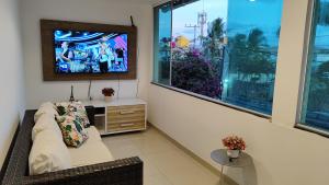 a living room with a couch and a tv at Onde a vida acontece in Salvador