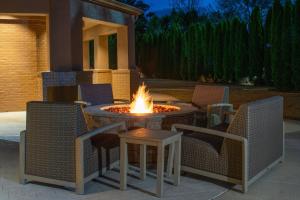 eine Feuerstelle auf einer Terrasse mit Stühlen und einem Tisch in der Unterkunft Courtyard by Marriott Decatur in Decatur