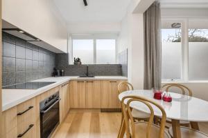 a kitchen with a table and chairs and a window at Stylish 2- Bedroom Unit near parks, shopping and dining in Melbourne