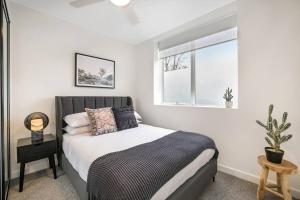 a bedroom with a bed and a window at Stylish 2- Bedroom Unit near parks, shopping and dining in Melbourne