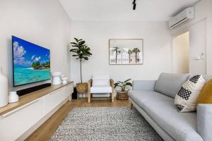 a living room with a couch and a tv at Stylish 2- Bedroom Unit near parks, shopping and dining in Melbourne