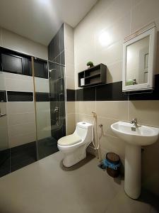 ein Bad mit einem WC und einem Waschbecken in der Unterkunft Luxury Homestay Bangalow Setia Residen Sitiawan 12pax in Sitiawan