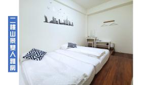 a white bedroom with a bed and a desk at 天天看海民宿 in Taitung City