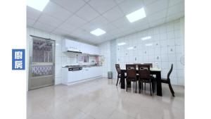 a white kitchen with a table and chairs in it at 天天看海民宿 in Taitung City